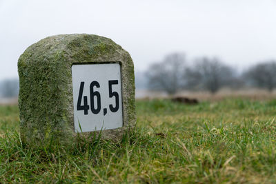 Close-up of road sign on field