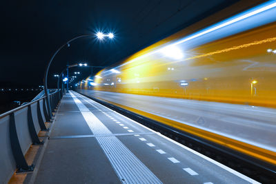 Blurred motion of light trails of a train on road at night 