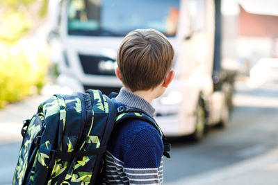 Boy looking away while standing outdoors