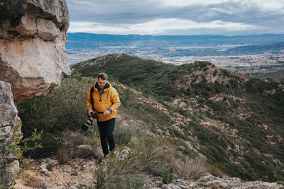 Full length of man standing on rocks against mountains
