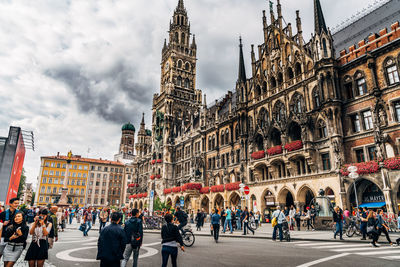 People walking on street by new town hall at marienplatz