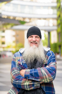 Portrait of man wearing hat standing in city