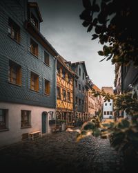 Street by buildings in town against sky