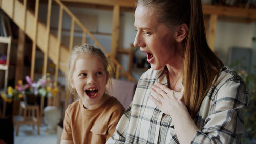 Mother and daughter laughing at home