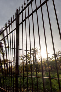 Low angle view of fence on field against sky