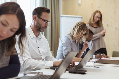 Business colleagues working on laptop at conference table in office