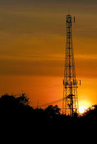 Low angle view of silhouette electricity pylon against sky during sunset