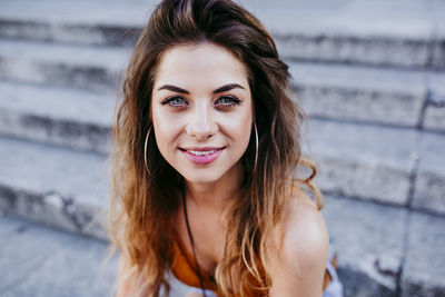 Close-up portrait of young woman sitting on staircase