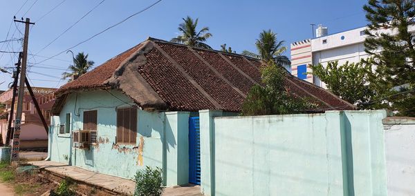 Exterior of house by building against sky