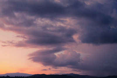 Low angle view of storm clouds in sky during sunset