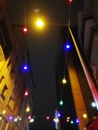 Low angle view of illuminated street lights at night