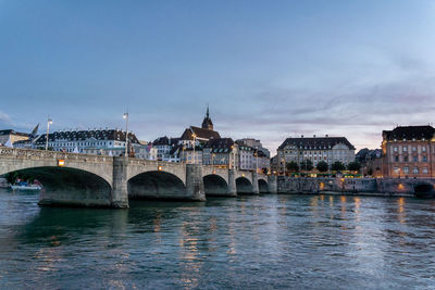 Bridge over river with city in background