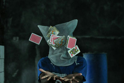 Obscured face of man playing cards