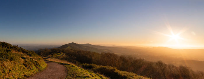 Road amidst landscape against sky during sunset