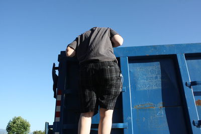 Low angle view of man on dumpster