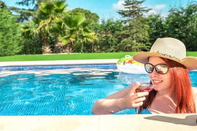 Portrait of young woman swimming in pool