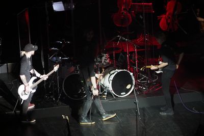 People playing guitar at music concert