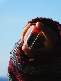 Close-up of woman holding ice cream cone against sky