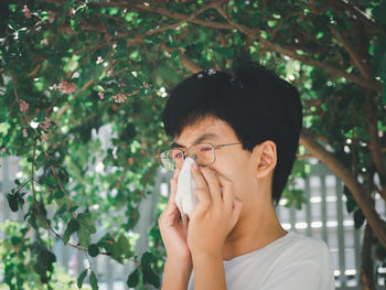 Portrait of young man holding plant