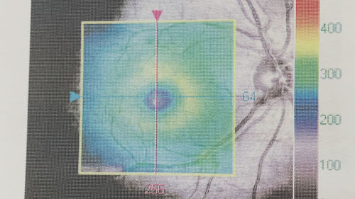 Close-up of multi colored paper against blue background