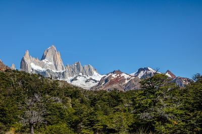 Scenic view of snowcapped mountains against clear blue sky