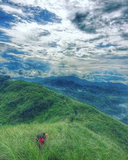 Scenic view of grassy field against cloudy sky