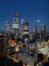 Illuminated buildings in city against sky at night