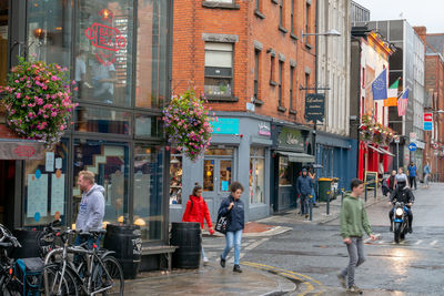 People walking on street against buildings in city