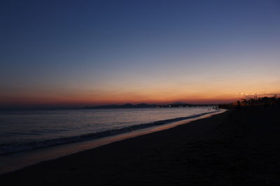 Scenic view of sea against clear sky at sunset