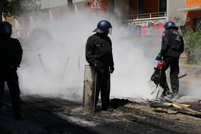Rear view of people standing on street in city