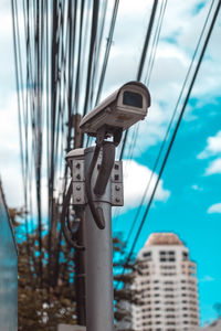 Close-up of telephone pole against sky in city