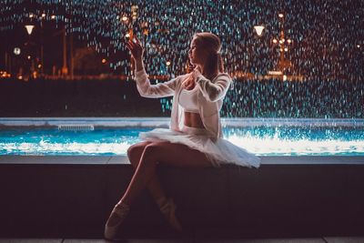 Woman sitting in swimming pool