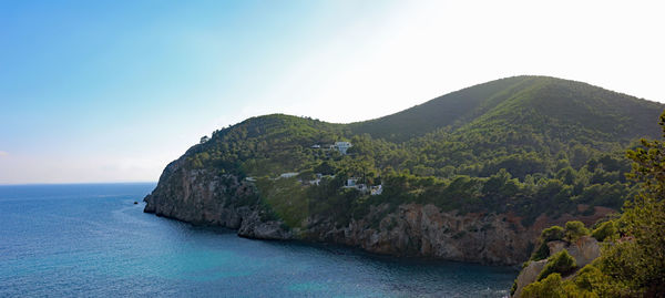 Scenic view of sea and mountains against clear sky