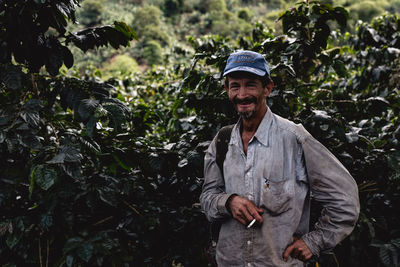 Portrait of smiling man standing against plants