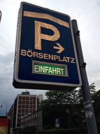 Low angle view of road sign against sky