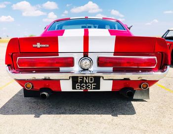 Red vintage car in city against sky