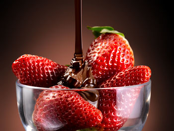 Close-up of strawberries in glass bowl against black background