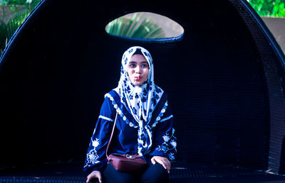 Portrait of young woman sitting outdoors