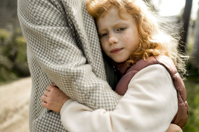 Daughter embracing mother on sunny day