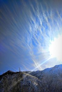 Low angle view of snowcapped mountain against blue sky