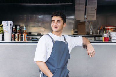 Man looking away while standing against food truck