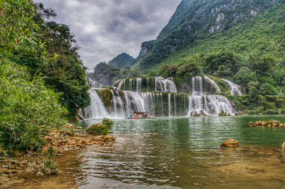 Scenic view of waterfall against sky