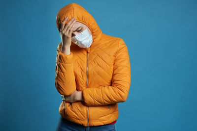 Woman standing against blue background