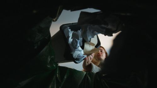 Botton view from trash. woman throwing crumpled paper in basket. ecology concept. recycling paper