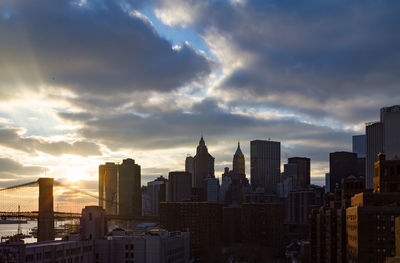 Buildings in city against cloudy sky