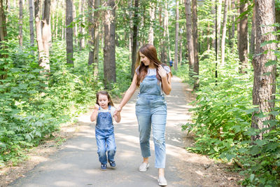 Full length of mother and daughter in forest