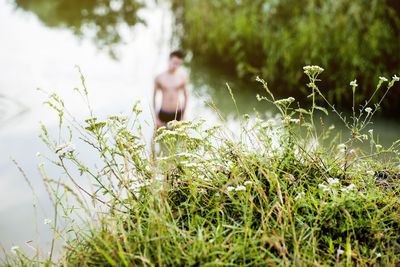 Shirtless man standing in lake