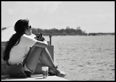 Side view of young woman sitting on horse against the sky