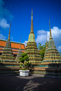 Potted plant by pagodas in temple against sky