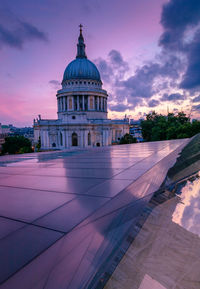 View of cathedral against dramatic sky in city during sunset